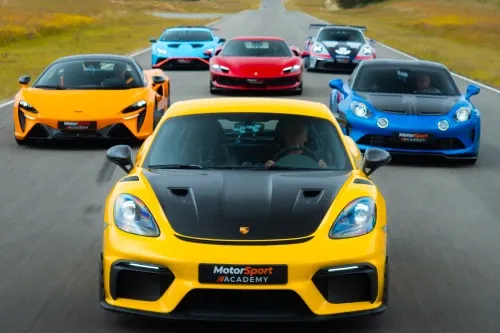 Le plateau de voitures de sport Motorsport Academy en formation sur circuit, une Porsche jaune en tête