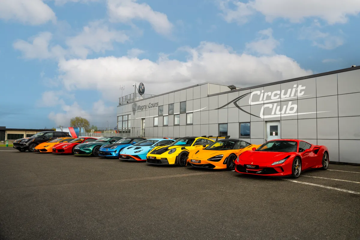 Alignement de voitures de sport devant le bâtiment du Circuit Club